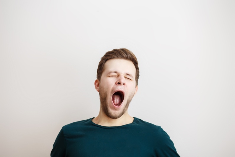 Portait of a yawning man on a light background