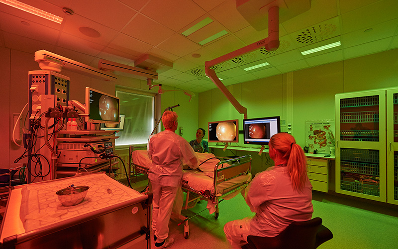Doctor and nursing performing an endoscopic procedure on a patient in an operating theatre with ergonomic lighting