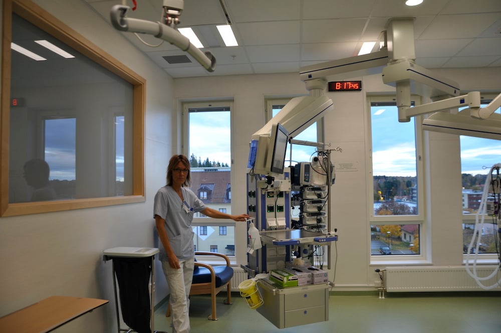 Sygeplejerske står på hospitalsstue og viser hvordan Chromavisos betjeningssystem virker
