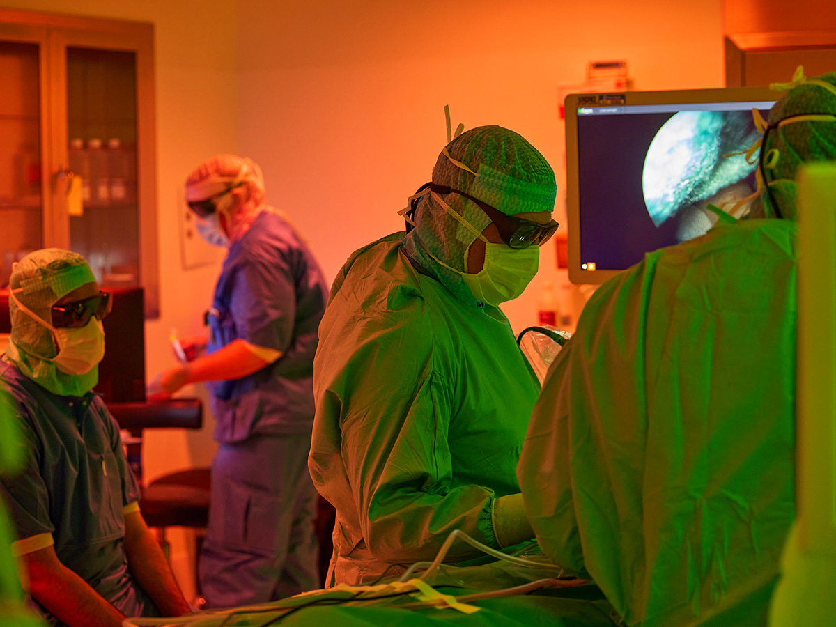 Kirurger og sygeplejersker i gang med at operere på en patient på en operationsstue med ergonomisk lys