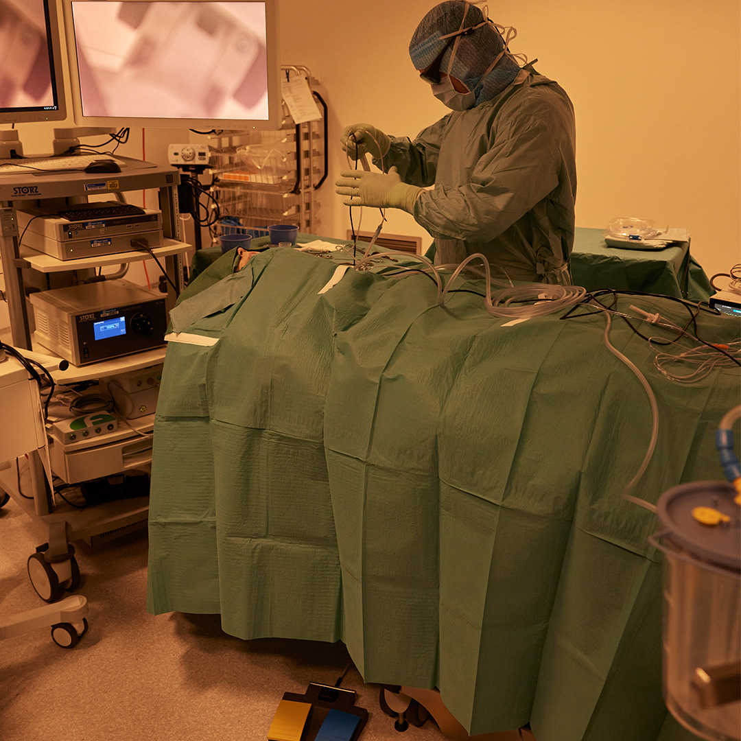 Uniformed surgeon preparing a patient for surgery in an operating theatre