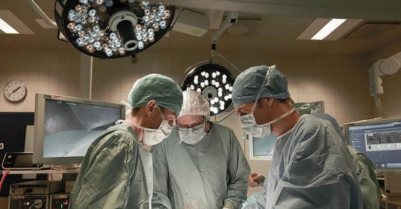 Three surgeons during open surgery under white light