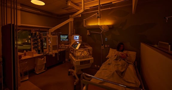 Mother sits with infant in amber circadian light in the neonatal ward at Akademiska Sjukhuset in Uppsala