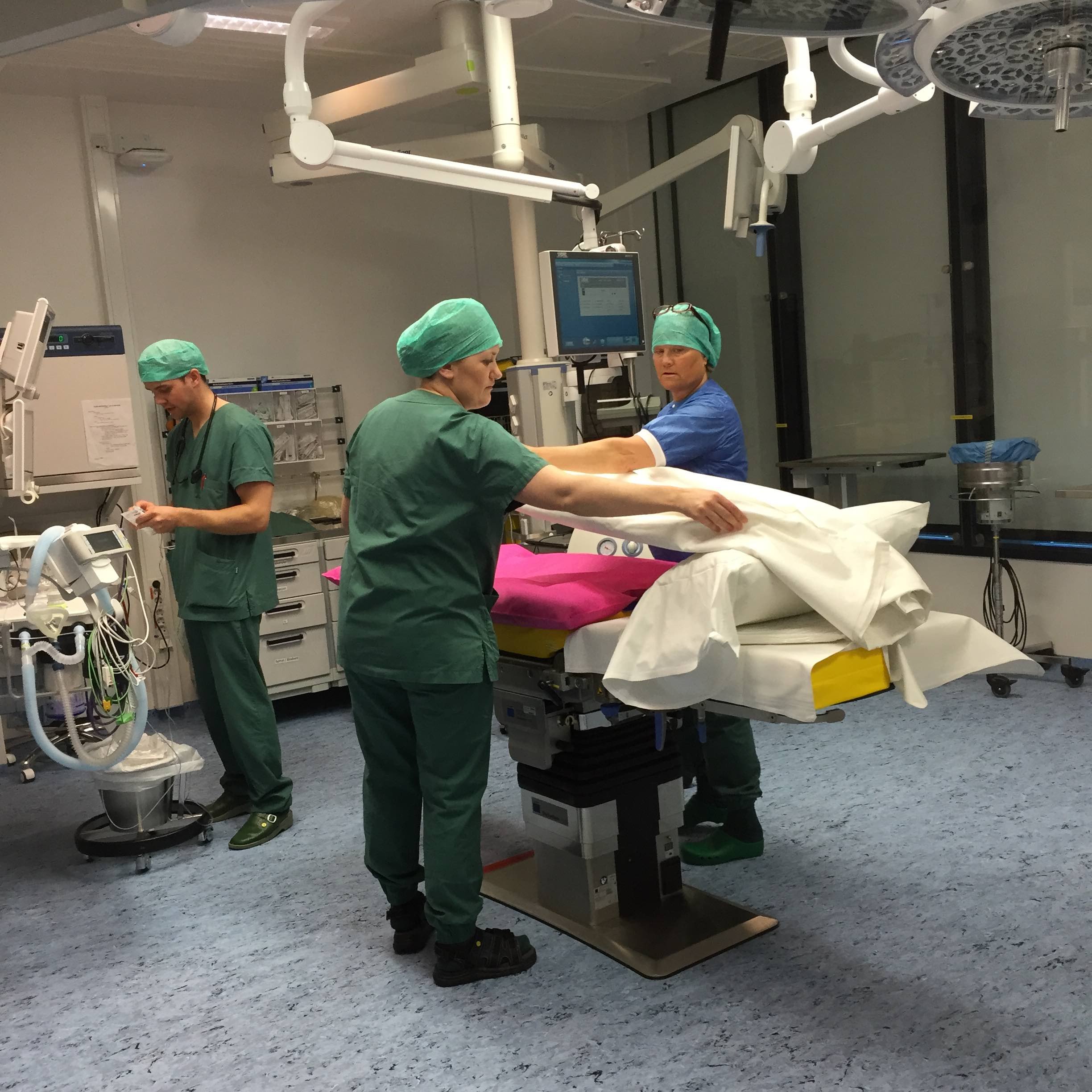 Uniformklædt sundhedspersonale gør klar til operation på operationsstue med ergonomisk lys