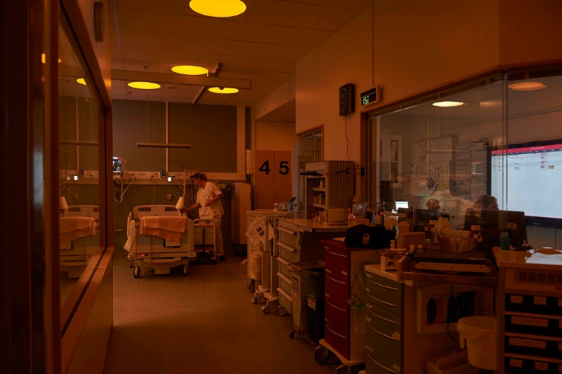 A nurse is caring for a patient in a hospital unit with circadian lighting