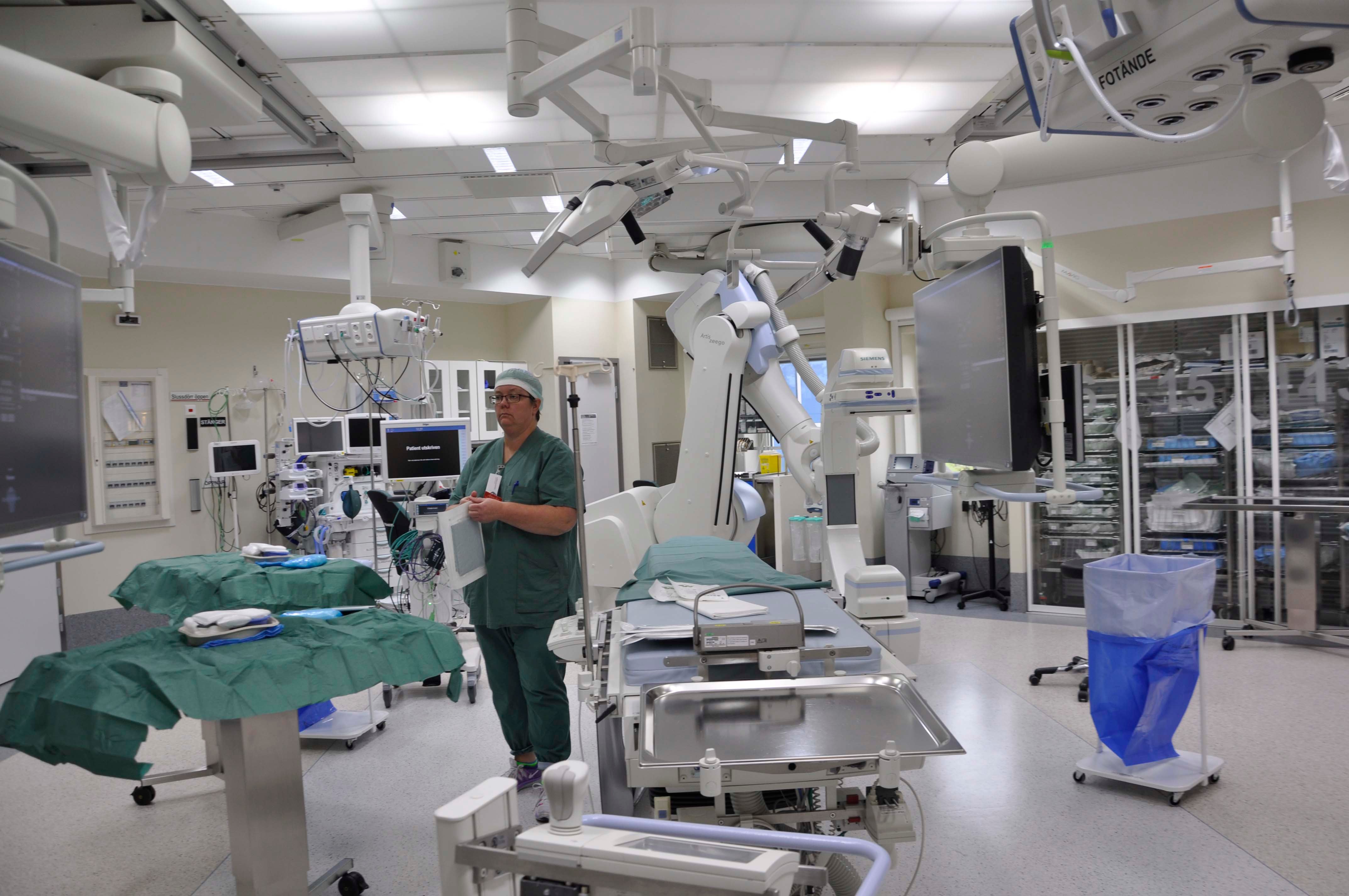 Healthcare personnel stand and prepare for surgery in the operating theatre